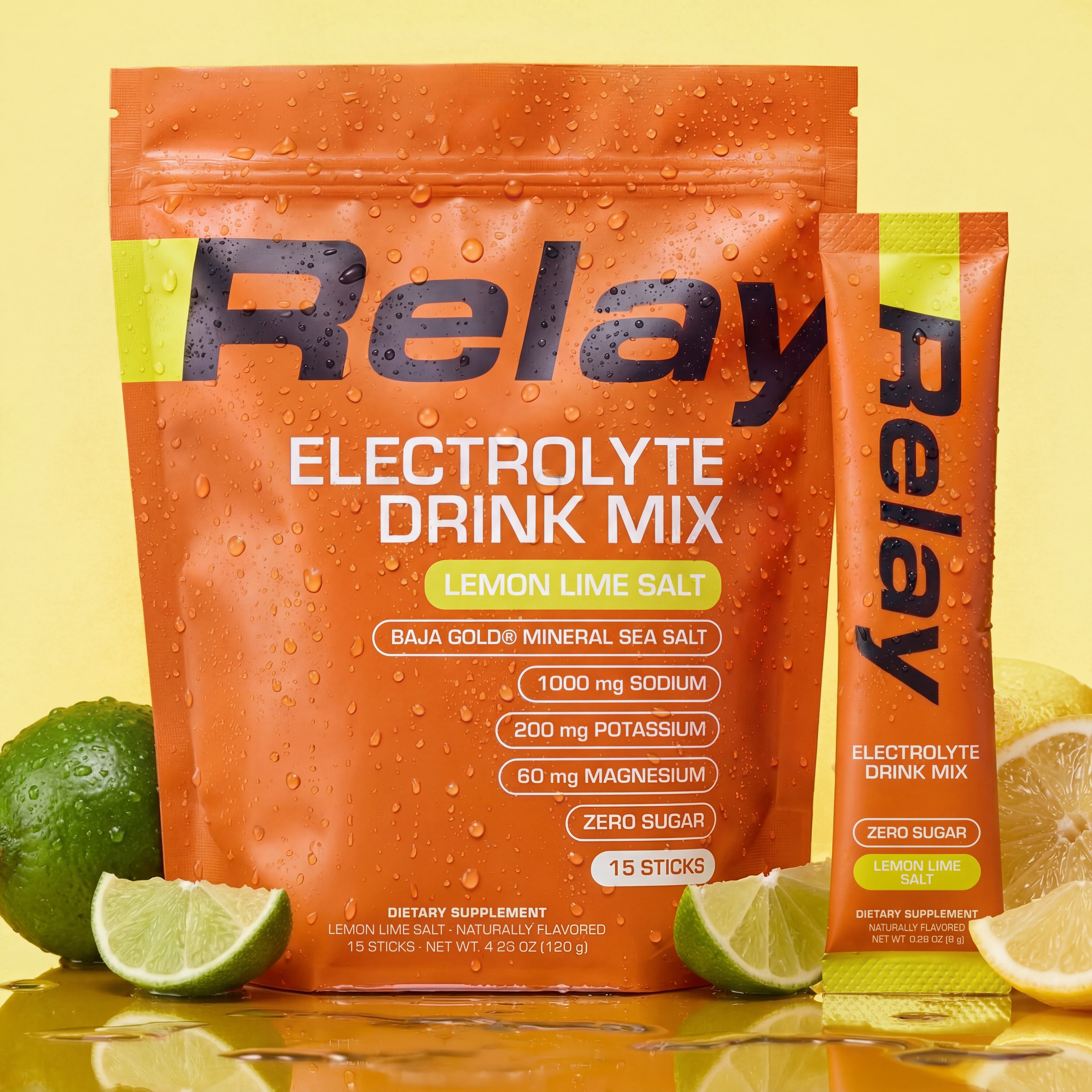 variant:49281673330925 Orange Relay Electrolyte Drink Mix package with lemons and limes on a yellow background