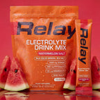 variant:49281673265389 Orange Relay Electrolyte Drink Mix package with watermelon slices on a light background